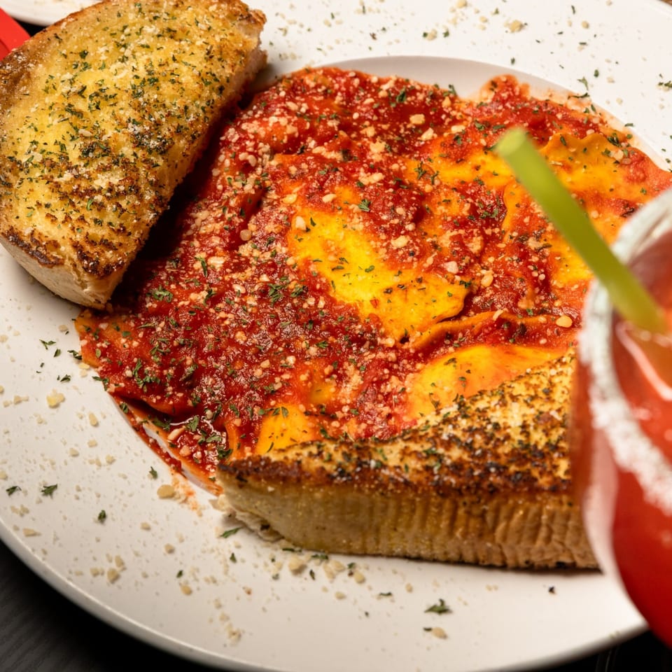 San Marino Italian Restaurant's ravioli with red sauce, parmesan, parsley, and garlic bread.